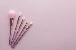 many makeup brush on pink background photo