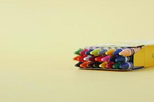 Color pencils on yellow papers on table photo