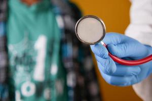 Doctor using a stethoscope checking body, close up photo