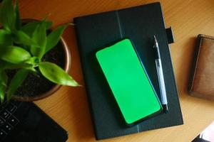 top view of smart phone and notepad on table photo