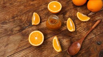 Jar of orange jam on wooden background from top view. photo