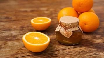 Jar of orange jam on wooden background from top view. Homemade marmalade photo