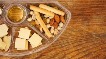 conjunto de alimentos en un recipiente de plástico. plato de queso para un picnic foto