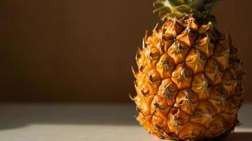 Exotic fruit pineapple on white table. Top view, copy space. Hard light, shadow photo
