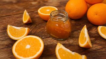 Jar of orange jam on wooden background from top view. Homemade marmalade photo