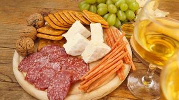 Snacks for wine. Cheese and meat plate. Sausages, cheese, nuts, grapes, crackers photo