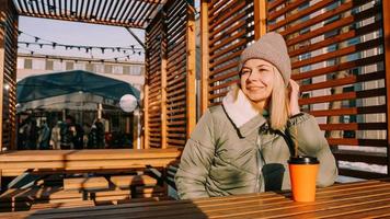 feliz joven mujer rubia en un día soleado de invierno en una feria de comida callejera foto