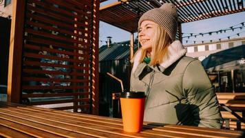 feliz joven mujer rubia en un día soleado de invierno en una feria de comida callejera foto