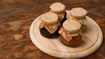 Four glass jars with different kinds of jam on wooden table. Homemade jam photo