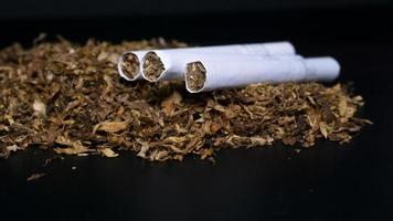 Pile of tobacco and some cigarette on a black background photo