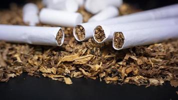 Cigarette Cotton Sponge Filter, Pile of tobacco and some cigarette on a black background photo