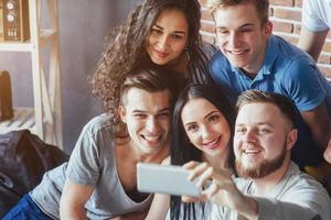 agrupar a hermosos jóvenes haciendo selfie en un café, mejores amigos niñas y niños juntos divirtiéndose, planteando un concepto de estilo de vida emocional foto