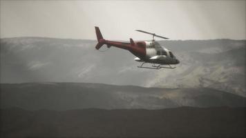 Helicóptero volador en cámara lenta extrema cerca de montañas con niebla video