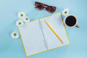 On the blue background notebook pencil, ruler and white flowers photo