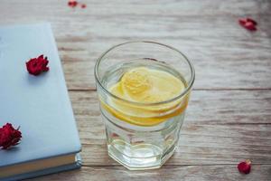 book glasses and flower petals  glass of water with lemon. photo