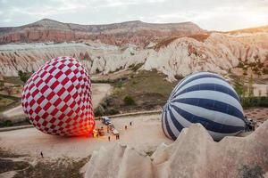 Hot air balloon flying over rock landscape at Turkey. Cappadocia photo