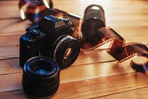 Old photo film and analog camera on table. Roll of photographic . Beautiful vintage design.