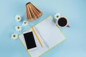 On the blue background notebook pencil, ruler and white flowers photo