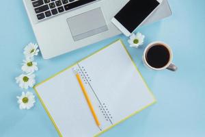 On the blue background notebook pencil, ruler and white flowers photo