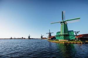 Colorful spring day with traditional Dutch windmills canal in Ro photo