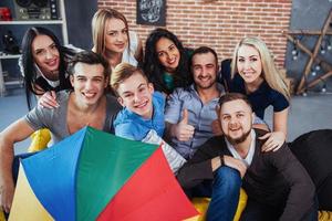 Group portrait of multi-ethnic boys and girls with colorful fashionable clothes holding friend posing on a brick wall, Urban style people having fun, Concepts about youth togetherness lifestyle photo