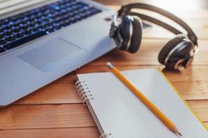 Laptop notebook headphones and olivchem on a light wooden background. photo