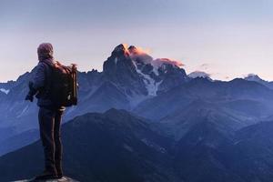 fotógrafo profesional toma fotos con una cámara grande en la cima de la roca