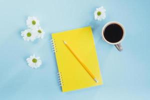 en el cuaderno de fondo azul lápiz, regla y flores blancas foto