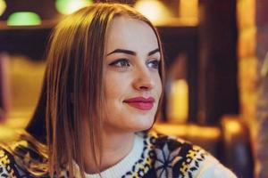 Young beautiful woman sitting in cafe, drinking coffee. Model looking up. Christmas, new year, Valentines day, winter holidays concept photo