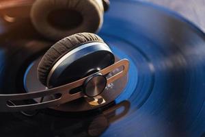 vinyl record and headphone over wooden table photo