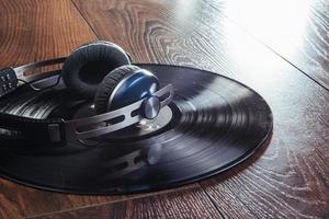 vinyl record and headphone over wooden table photo