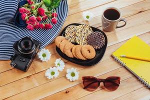 Coffee espresso stands on a wooden table with cookies, pad and pencil. photo