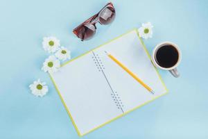 On the blue background notebook pencil, ruler and white flowers photo