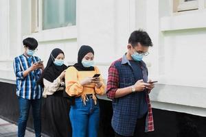 Group of young people in a row keeping social distancing against the diffusion of the coronavirus or covid-19 pandemic disease. New normal concept photo