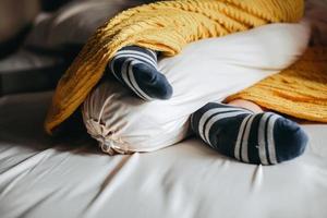 People sleep under blankets and hug bolsters in warm socks photo