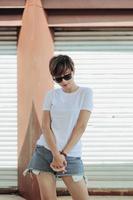 Mock up of white t-shirt and short pants with sunglasses wearing by beautiful stylish short hair woman photo