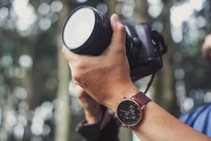 mano del fotógrafo sosteniendo una cámara réflex digital foto