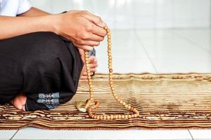 Side view of muslim man's hand holding rosary to count dzikir. photo