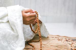 Muslim woman's hand holding rosary to count dzikir photo