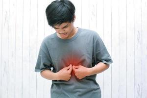 Young asian have symptoms of burning sensation in the middle of the chest caused by acid reflux. photo