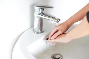 lavado de manos con agua corriente del agua del grifo de plata foto