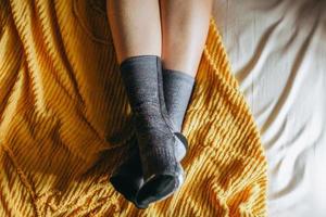 Top view of foot in warm socks on the bed photo