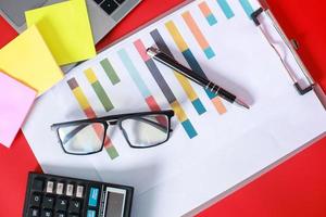 Flat lay top view of messy office accessories isolated on red background photo