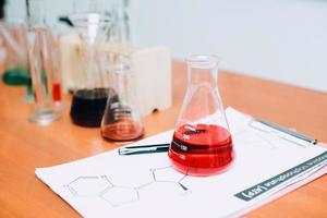 líquido rojo en el vaso de precipitados con equipo de laboratorio sobre la mesa. día nacional de la ciencia, día mundial de la ciencia foto