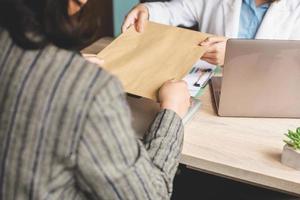 Cropped shot of business woman giving envelope to colleague. Promotion, HR concept, unemployment concept, searching for job, envelope with Job offer message photo