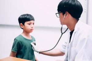 Male doctor hold stethoscope examining child boy patient, check heart lungs of kid do pediatric checkup in hospital, children medical care concept photo