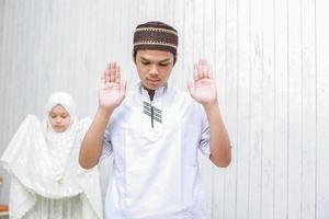 pareja joven musulmana haciendo salah junto con levantar la mano o takbiratul ihram pose foto