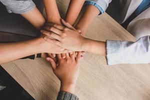 Top view of young business people putting their hands together photo