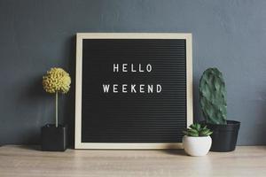 HELLO WEEKEND quote on blackboard with cactus, succulent and decorative plant on wooden table photo