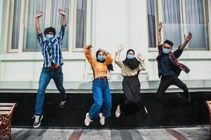 Blurry photo group of people with medical mask for corona virus jumping, Youth, city lifestyle, team, friendship concept